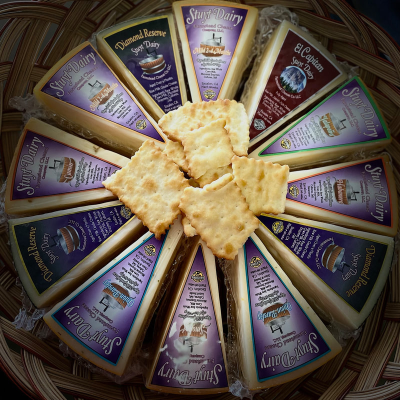 Image contains packaged cheeses in a round circle. 