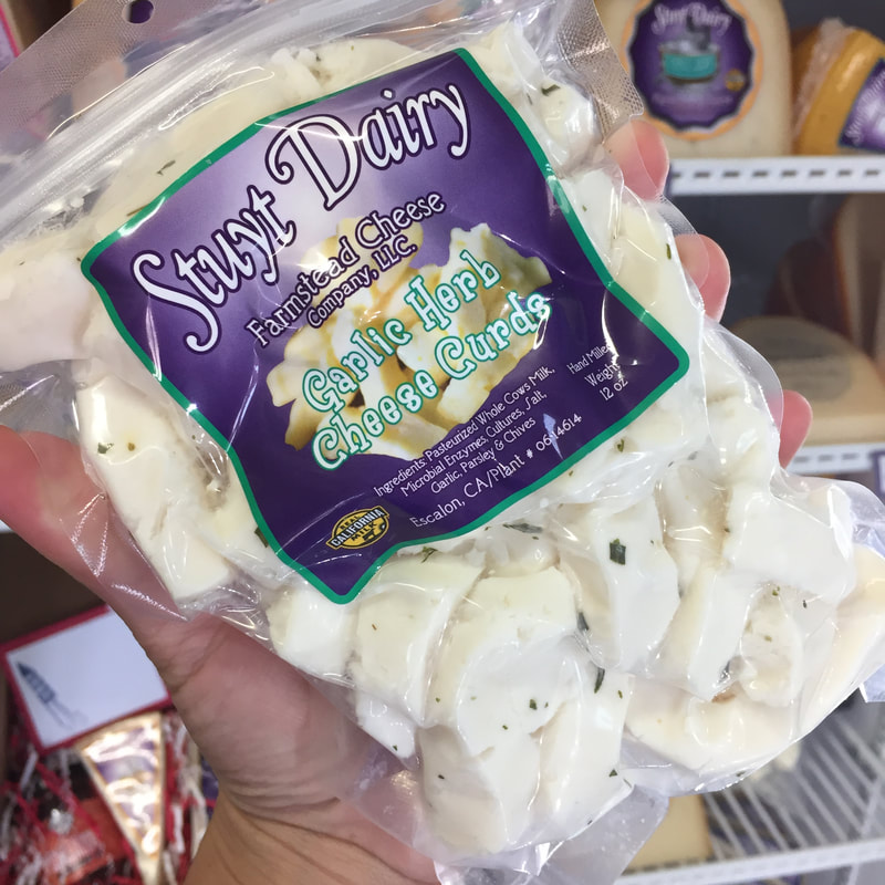 Image contains a bag of garlic herb flavored fresh cheese curds. 