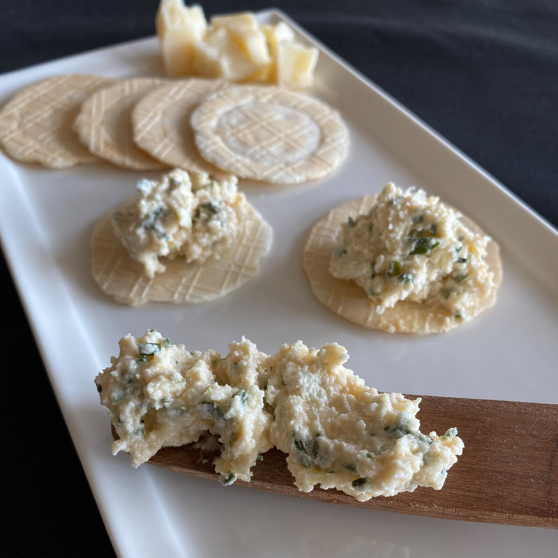 Image contains fresh cheese spread topped on crackers. 